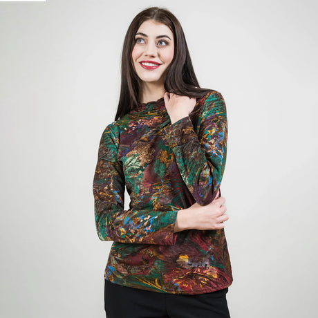 Woman wearing a colorful patterned top against a plain background