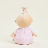 Stuffed doll with a pink polka dot dress on a beige background