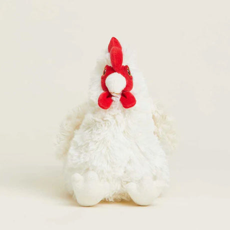 White plush toy with red accents on a light beige background