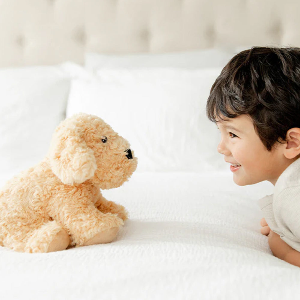Child lying on a bed with a teddy bear